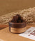 Wooden incense holder with 'HomeFlower' branding on a brown surface with dried plants in the background.