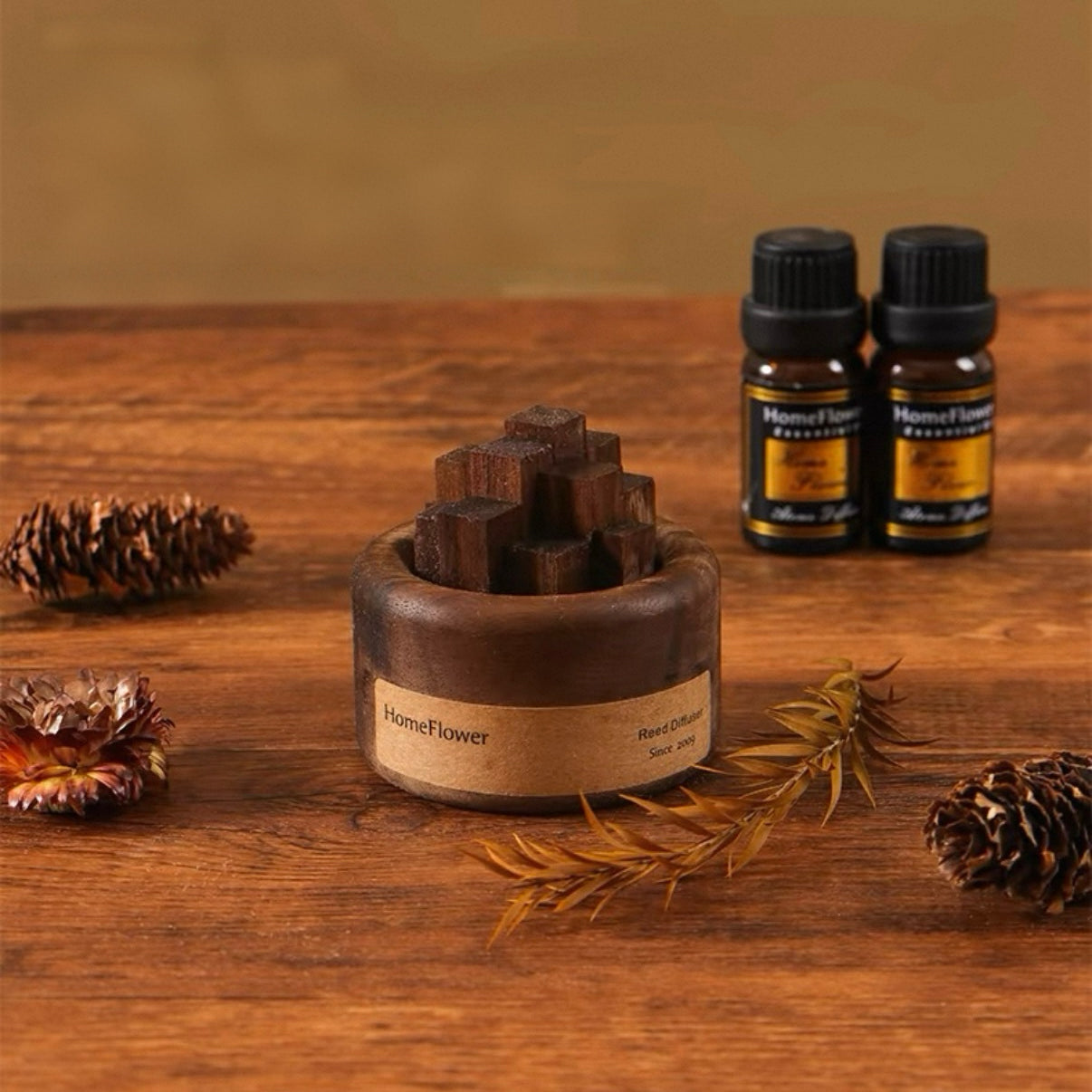 Wooden diffuser and essential oil bottles on a wooden surface with pine cones and branches.