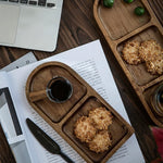 Wooden tray with cookies and a cup of coffee on a desk next to a laptop
