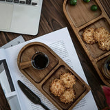 Wooden tray with cookies and a cup of coffee on a desk next to a laptop
