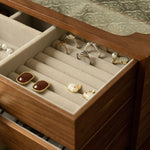 Wooden jewelry box with rings and earrings on a textured surface