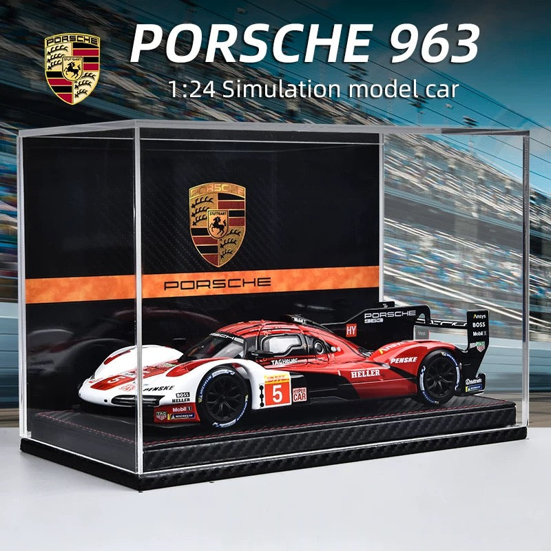 Porsche 963 model car in a display case with Porsche logo.