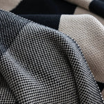 Close-up of a textured fabric with a checkered pattern in black, white, and beige.