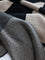 Close-up of a textured fabric with a checkered pattern in black, white, and beige.