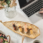 Laptop on a table with sushi, coffee, and flowers