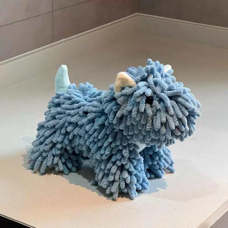 Blue plush toy resembling a creature on a light-colored floor.