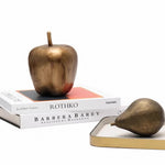 Bronze apple and pear on books with a white background