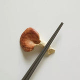 Two wooden chopsticks on a light gray background