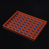 Wooden tray with blue checkered pattern on a black background