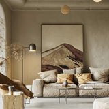 Modern living room with a mountain painting on the wall, neutral color scheme.