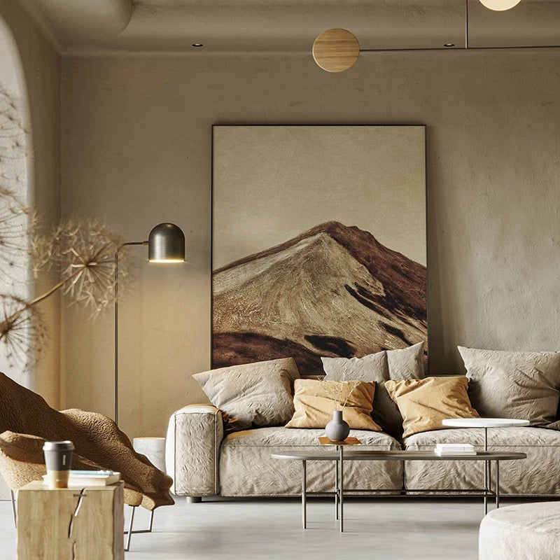 Modern living room with a mountain painting on the wall, neutral color scheme.
