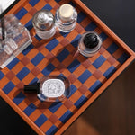 Set of nail polish bottles on a checkered wooden tray