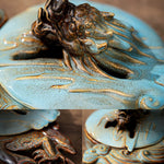 Decorative ceramic piece with fish design on a textured surface