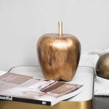 Bronze apple-shaped object on a magazine with a white background