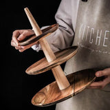 Person holding a wooden tiered stand with a dark background