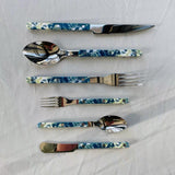Set of floral-patterned cutlery on a white fabric background