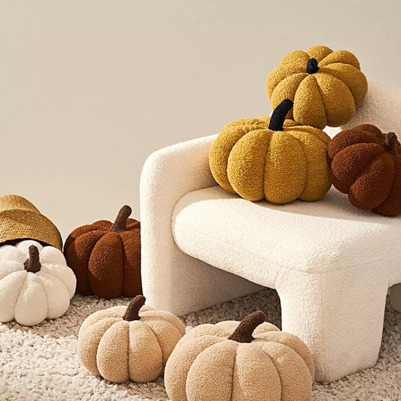 Decorative pumpkins in various colors on a white chair and floor.