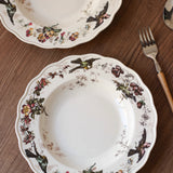 Decorative ceramic plates with floral and bird patterns on a wooden surface.