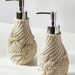 Two decorative soap dispensers with shell designs on a white background