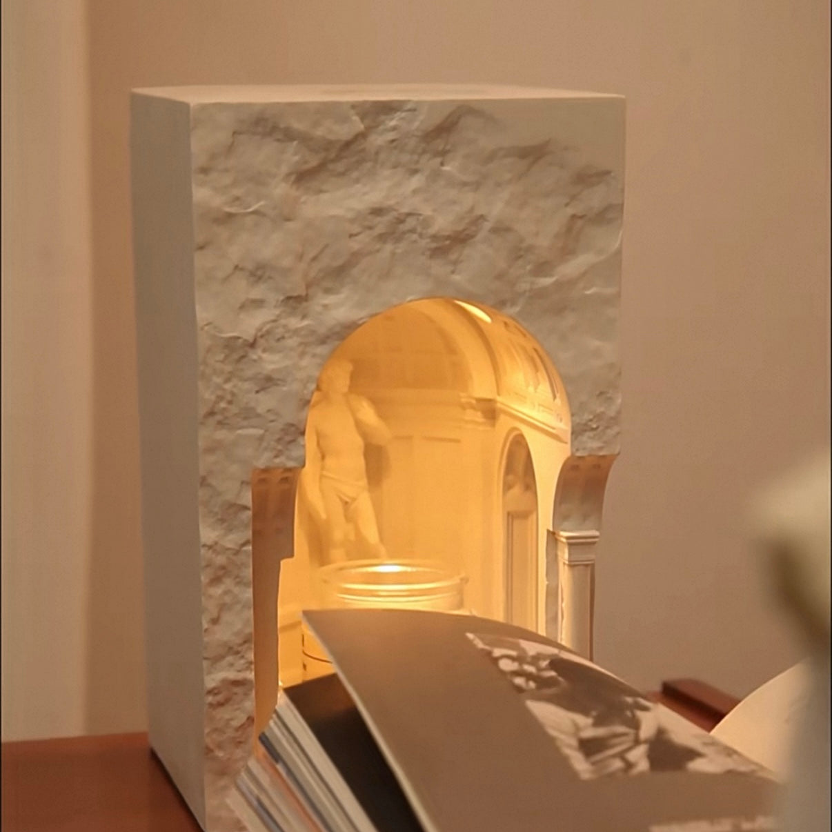 Decorative lamp with marble base and gold interior on a table.
