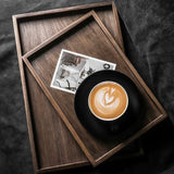 Wooden tray with a cup of coffee and a photo on a dark surface