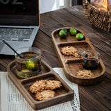 Wooden trays with snacks and drinks on a wooden table with a laptop and newspaper.