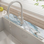 Kitchen sink with marble-like backsplash and modern faucet
