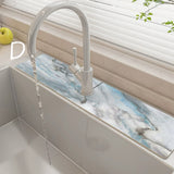Kitchen sink with marble-like backsplash and modern faucet