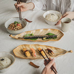 Person eating a meal with chopsticks at a table with various dishes.