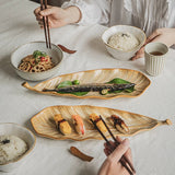 Person eating a meal with chopsticks at a table with various dishes.