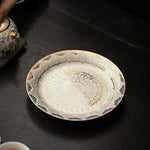 Decorative ceramic plate with gold patterns on a dark surface