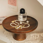 Wooden stand with jewelry and a bottle of perfume on a lace tablecloth.