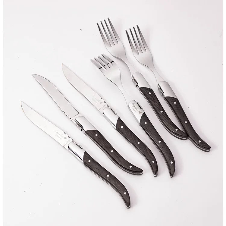 Set of knives and forks with wooden handles on a white background