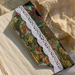 Decorative ribbon with floral pattern and lace edge on a textured fabric background