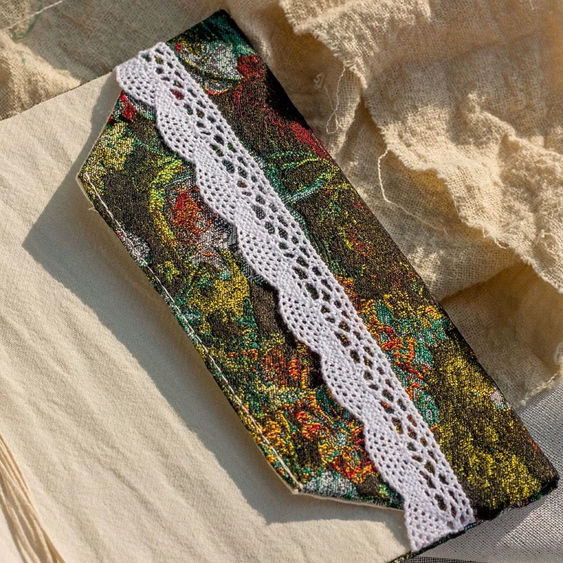 Decorative ribbon with floral pattern and lace edge on a textured fabric background