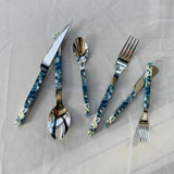 Set of floral-patterned cutlery on a light gray background