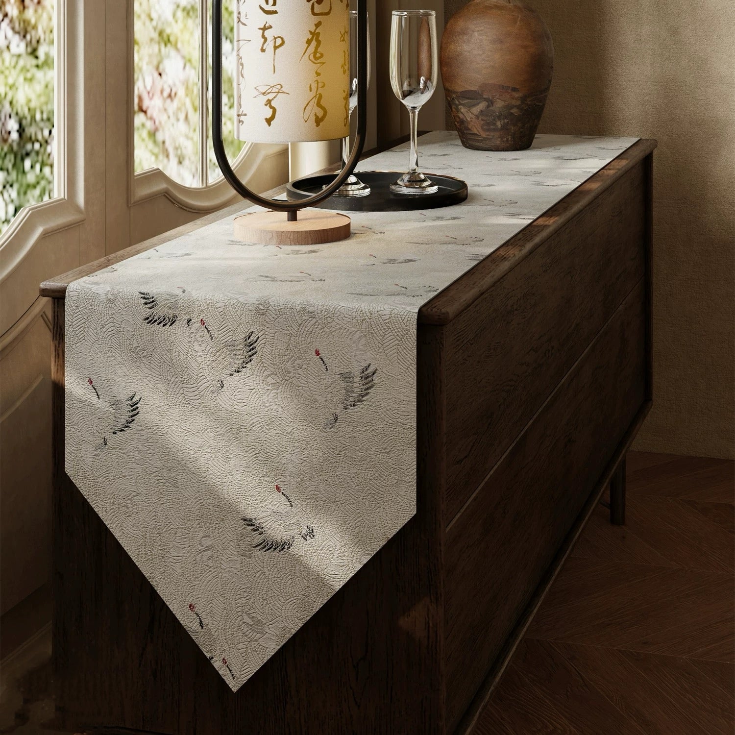 Table runner with feather design on a wooden table near a window