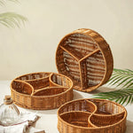 Set of wicker trays with compartments on a light surface with leafy background
