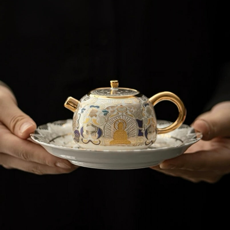 Ceramic teapot with intricate designs held by two hands on a dark background