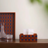 Decorative tissue box with checkered pattern on a wooden surface