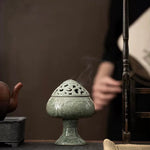 Decorative incense burner on a wooden surface with a blurred background