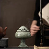 Decorative incense burner on a wooden surface with a blurred background