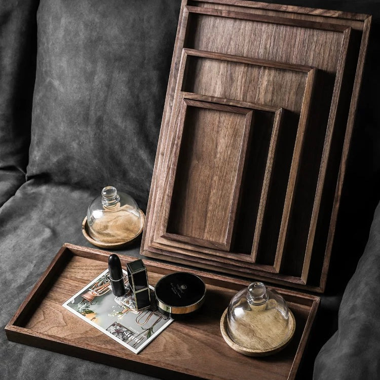 Set of wooden trays on a dark surface with decorative items.