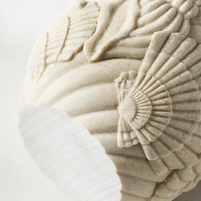 Decorative stone ball with intricate carvings on a light background