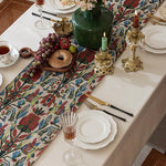 Elegant table setting with decorative tablecloth, plates, glasses, and candles.