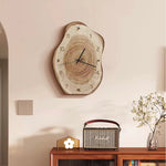 Wooden wall clock on a wall above a wooden console table with a radio and decorative items.