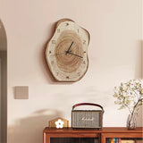 Wooden wall clock on a wall above a wooden console table with a radio and decorative items.