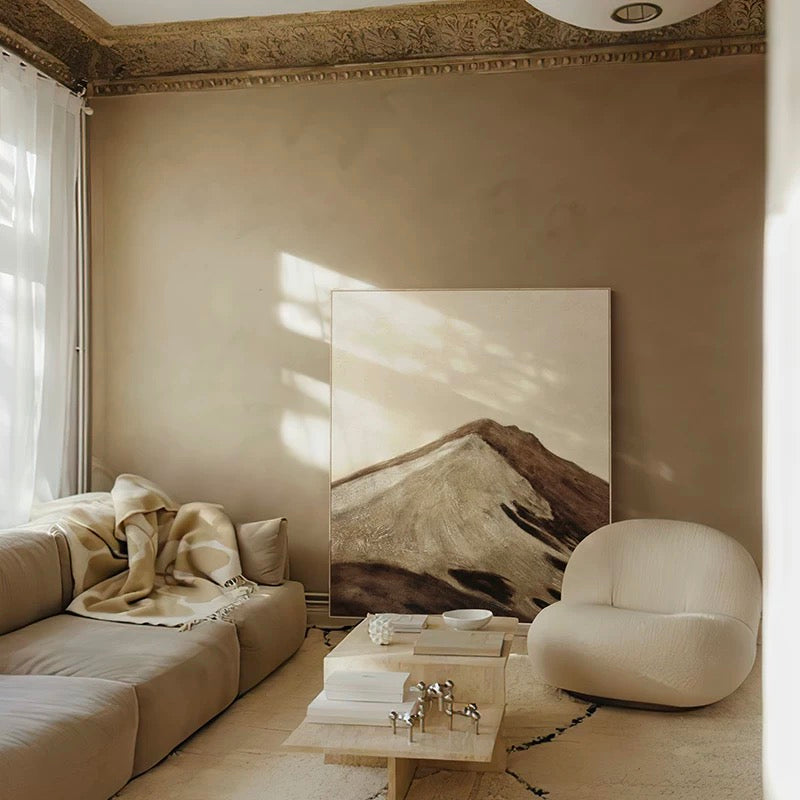 Modern living room with a large abstract painting on the wall, beige sofa, and armchair.
