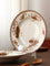 White plate with brown floral patterns on a stand