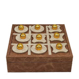 Wooden tic-tac-toe game set with gold pieces on a white background